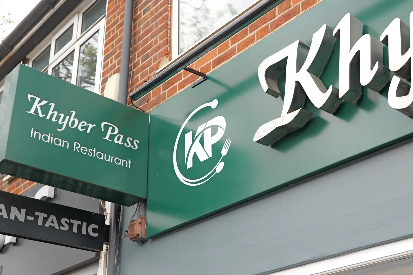 The Khyber Pass hanging sign and illuminated fascia lettering above the restaurant on Terrace Road, Walton-on-Thames
