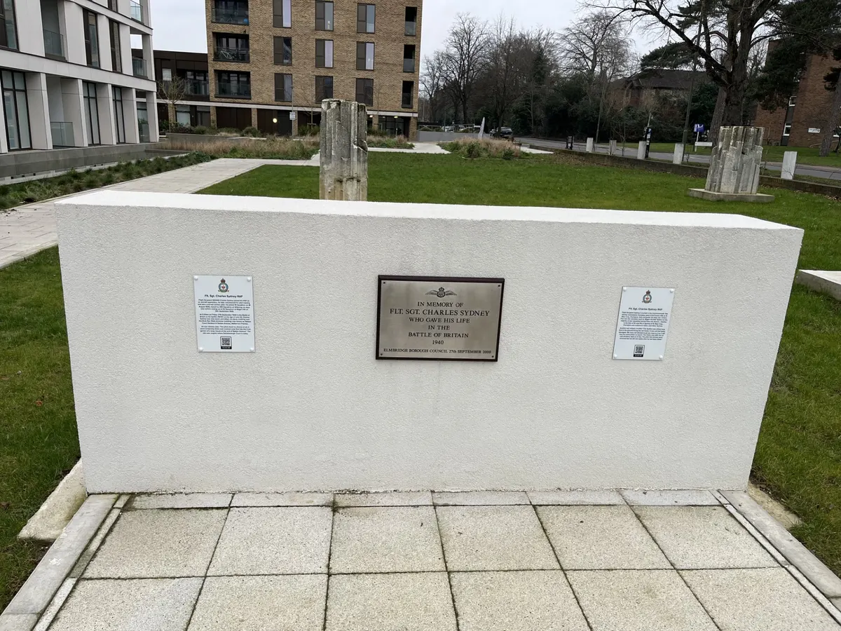 The replacement memorial to Flight Sergeant Charles Sydney at Walton Court Gardens, with the original 2000 plaque flanked by two new interpretive panels