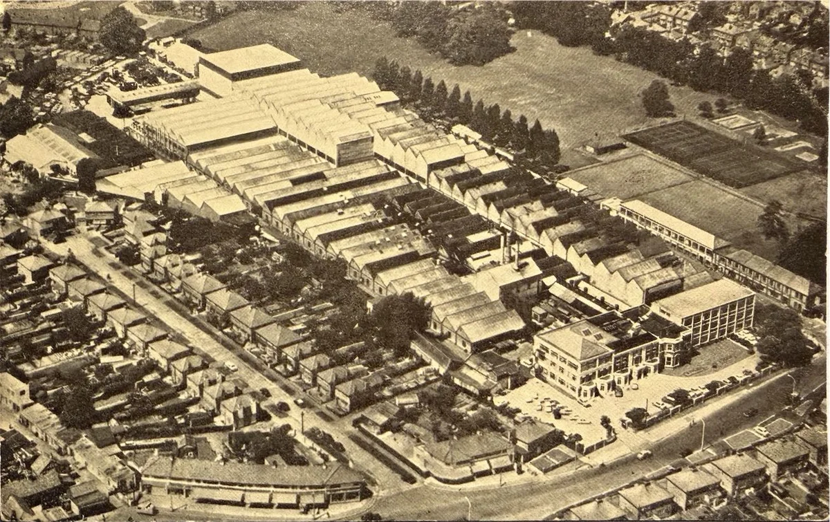 Aerial postcard view of the Hackbridge and Hewittic Electric Co works, Hersham, showing ranks of factory roofs behind the Molesey Road frontage