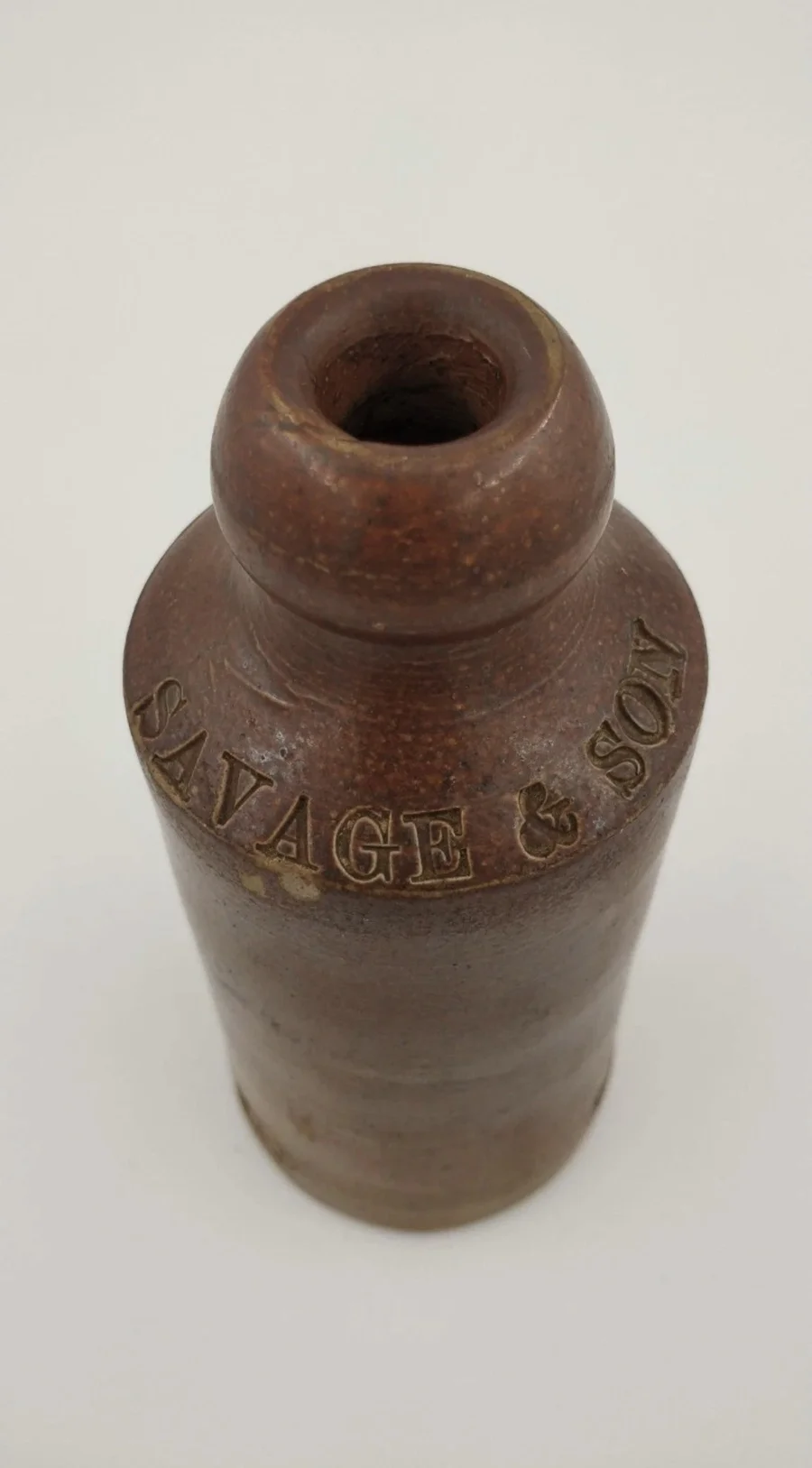 Close view of the shoulder of the stoneware Savage & Son bottle, embossed 'SAVAGE & SON'
