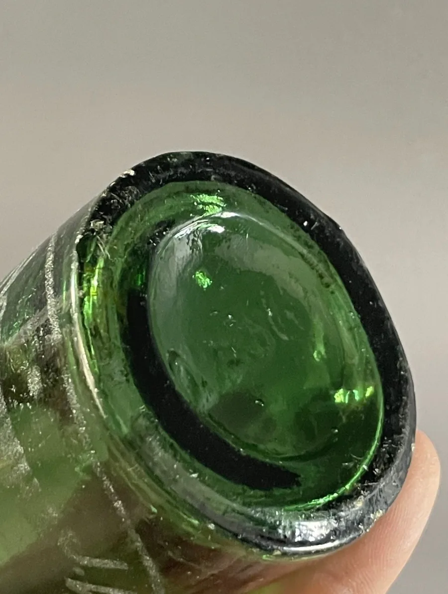 The base of the green Savage & Son bottle