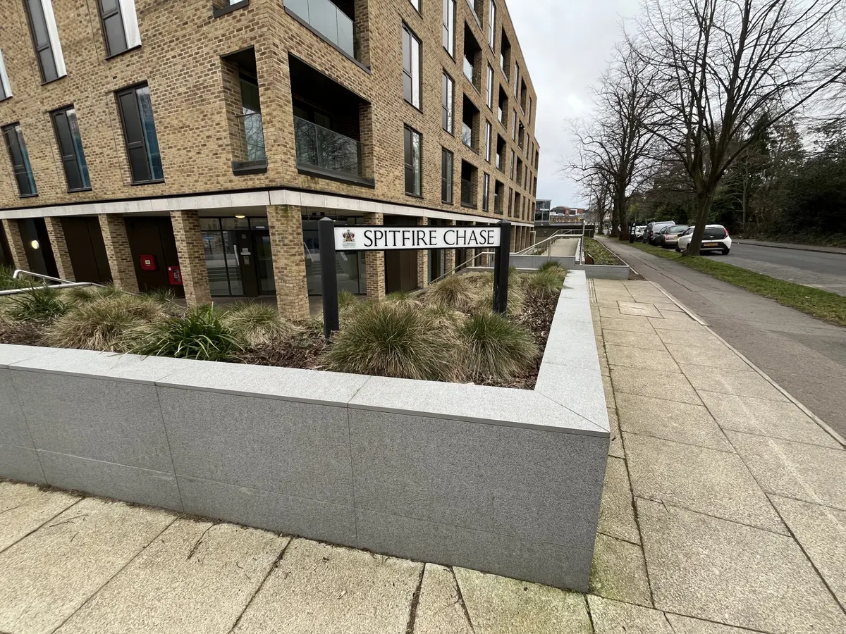 Street sign for Spitfire Chase, a road within the Walton Court Gardens redevelopment